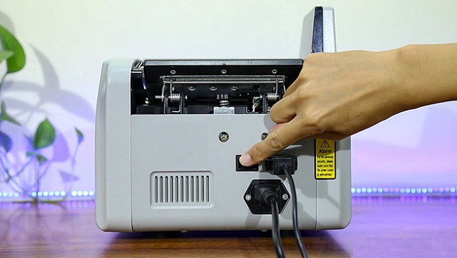 Nút công tắc nguồn thường nằm ở đằng sau máy đếm tiền